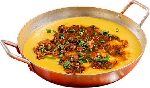 Fotografia da polenta caipira em panela: polenta amarela com ragú de carne e cebolinha.